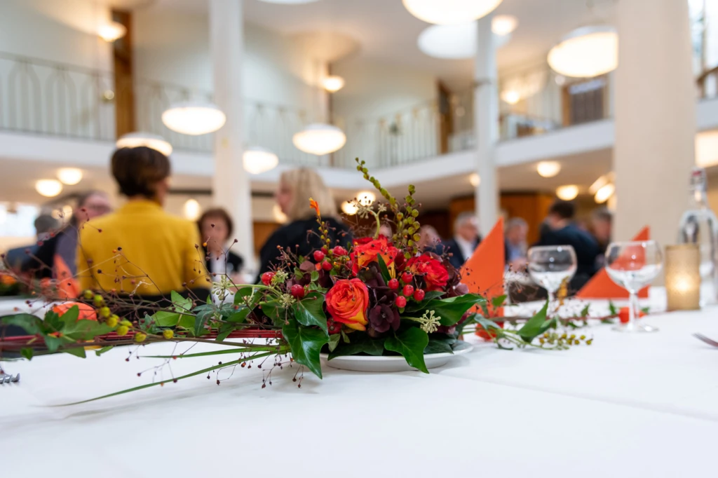 Bordsdekorantion i förgrunden med suddiga personer i bakgrunden